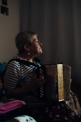 Waltraud sitzt mit Akkorden auf Couch Maximilian Gödecke Photography Berlin